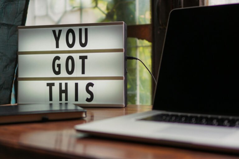 A sign reading You Got This is in focus with a laptop in the foreground.