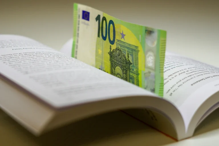 A hundred euro bill sits in a book.